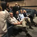 A group of people sitting in rows at an event.