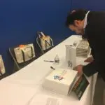 A man in black jacket cutting cake on table.