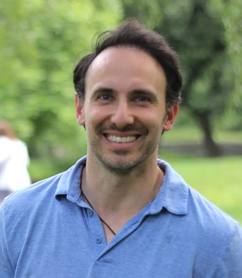 A man with a beard and mustache smiling for the camera.