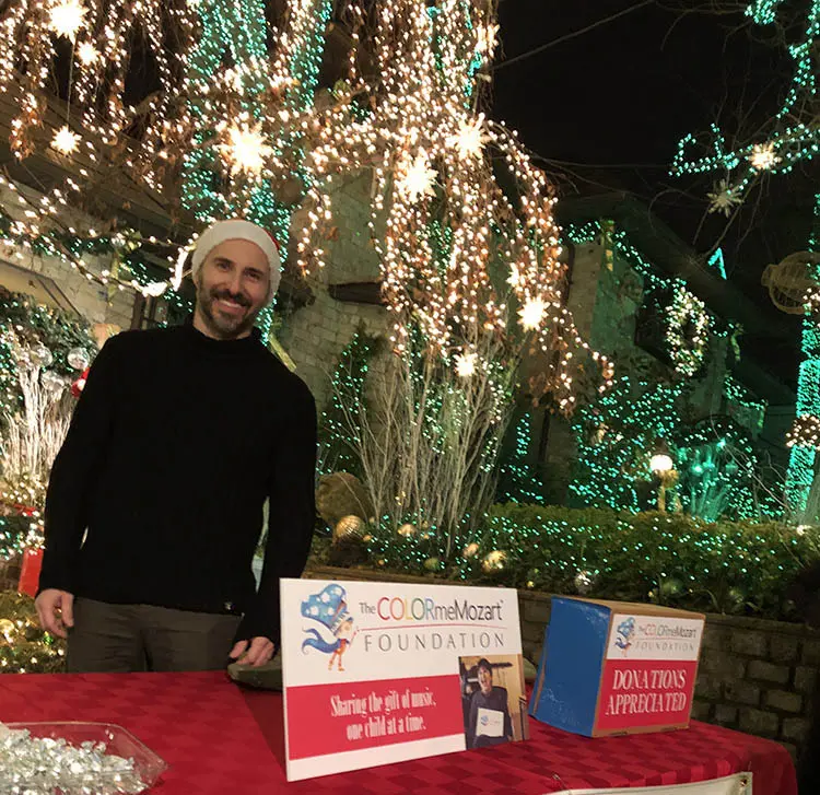 A man standing next to some lights at night