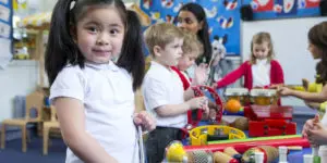 A group of children in school uniforms playing with toys.