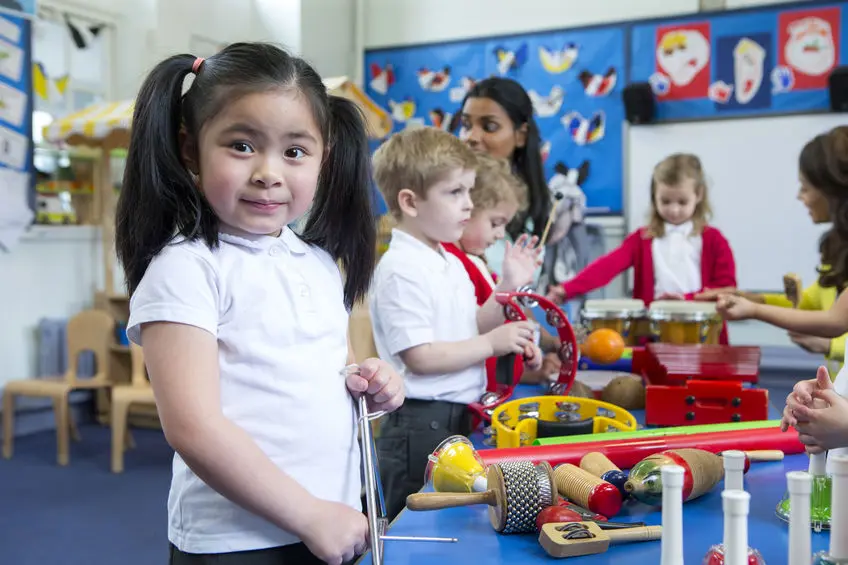 A group of children in school uniforms playing with toys.