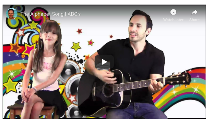 A man and girl singing together with a guitar.