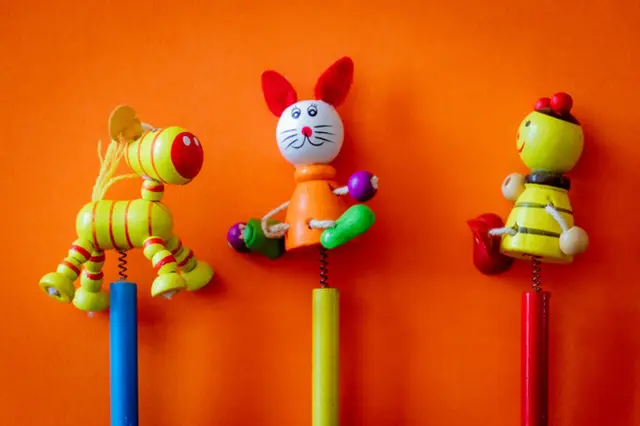 A group of three toy animals hanging on the wall.