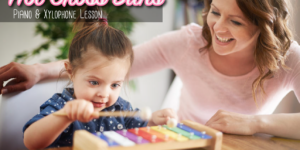 A woman and child playing with an instrument.