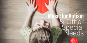 A boy holding a paper heart with the words music for autism & other special needs written on it.