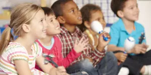 A group of children sitting in front of each other.