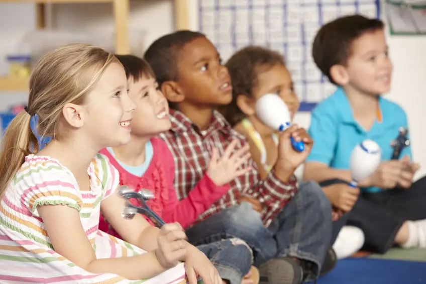 A group of children sitting in front of each other.