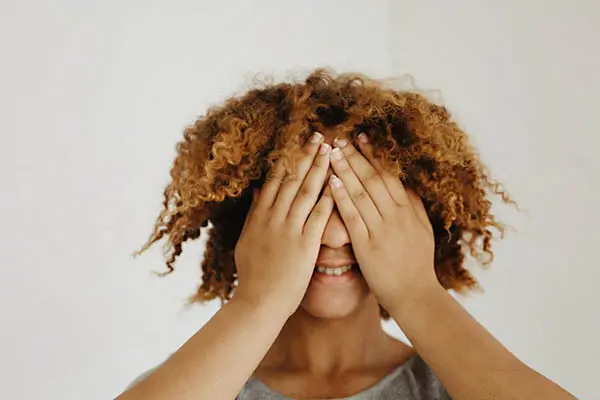 A woman covering her eyes with her hands.