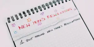 A notebook with the words new year 's resolutions written on it.