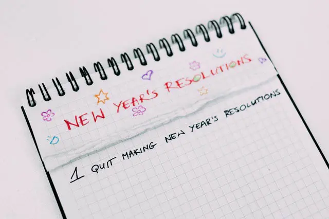 A notebook with the words new year 's resolutions written on it.