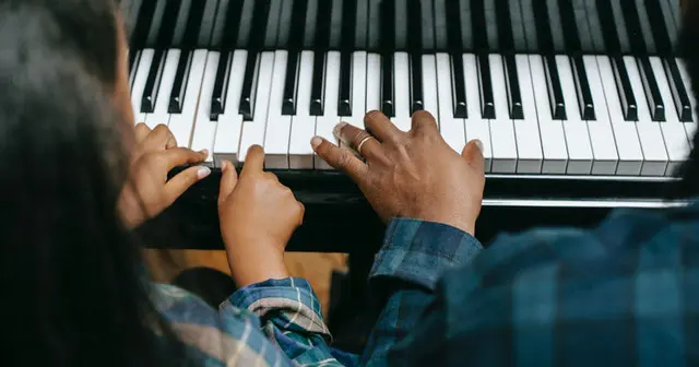 A person playing the piano with their hands