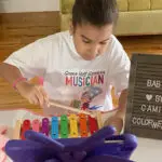 A young boy playing with a colorful xylophone.