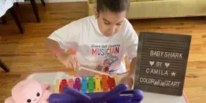 A young boy playing with a colorful xylophone.