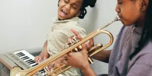 A girl and her mother playing musical instruments.