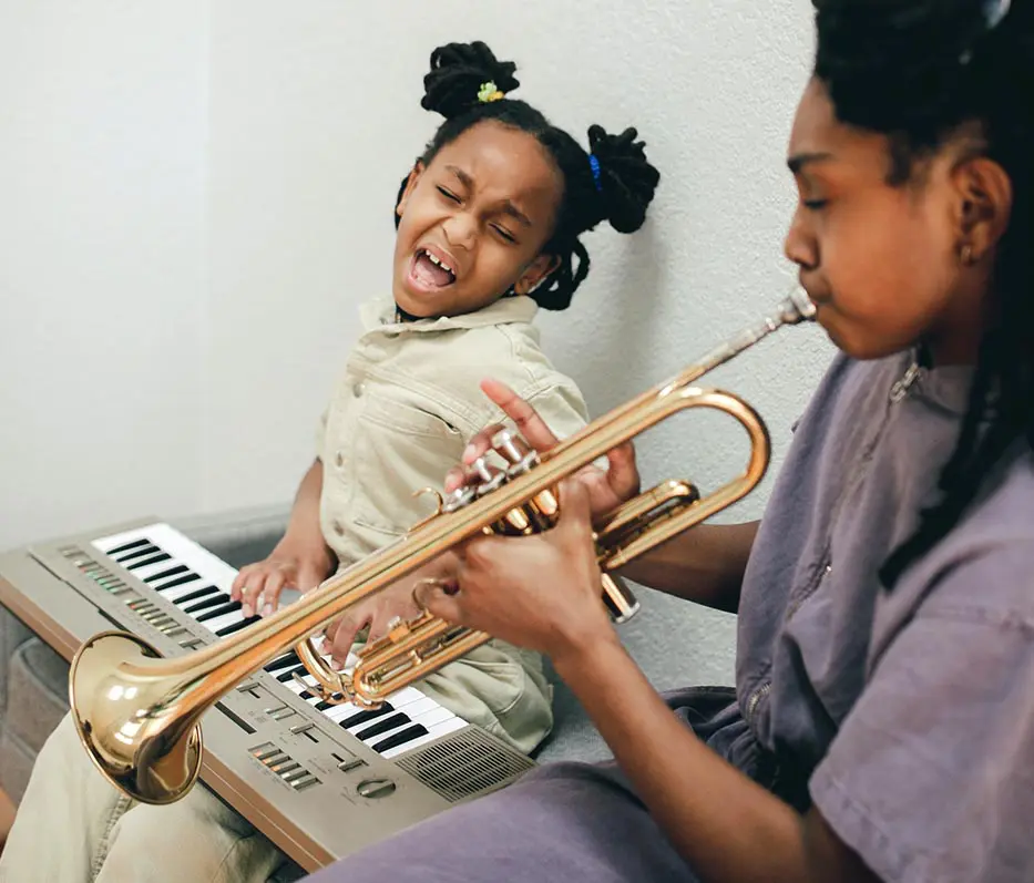 A girl and her mother playing musical instruments.