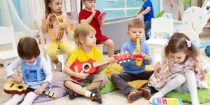 A group of children sitting on the floor playing with toys.