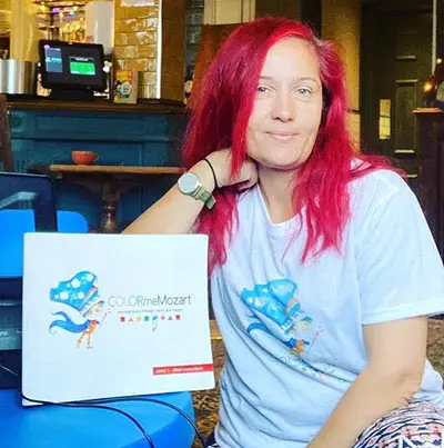 A woman with red hair sitting on the ground.