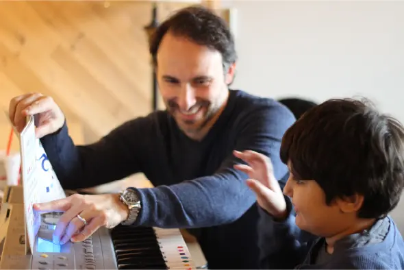 A man and boy playing piano together