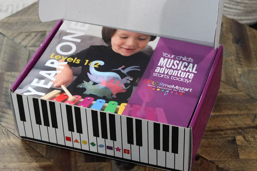 A box with a child playing on the piano.