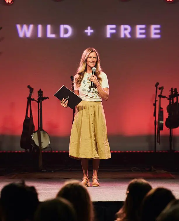 A woman standing on stage holding a microphone.