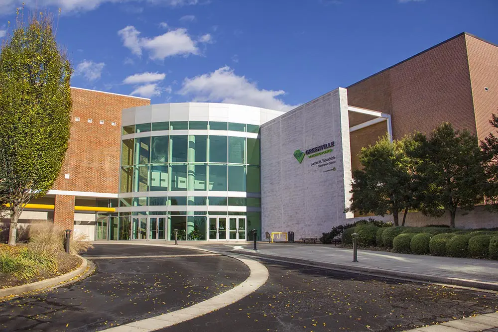 A building with a large window and a circular driveway.