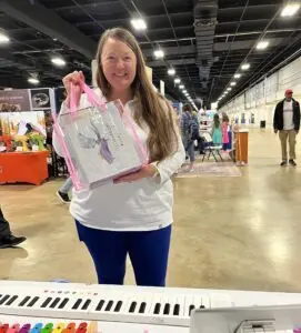 A woman holding up a bag with a picture of a person on it.