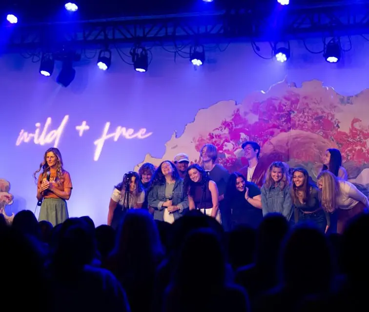 A group of people standing on stage with a microphone.