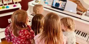 A group of children watching a video on the piano.