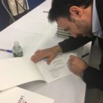 Closeup of Adrian Edward signing a copy of Color Me Mozart