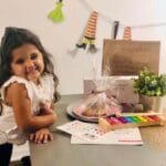 A little girl sitting at the table with some food.