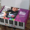A box with a child playing on the piano.
