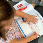 A little girl is reading a book