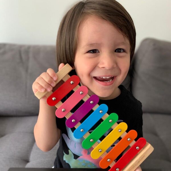 A little girl holding onto some colorful wooden toys