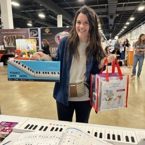 A woman holding two bags of music at an event.