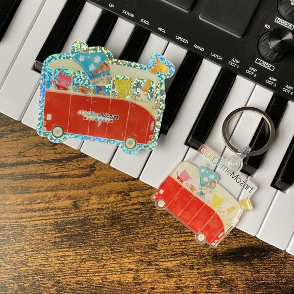 A key chain and two magnets on top of piano keys.