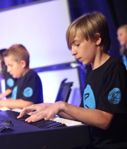 Child performing at homeschool music recital on piano