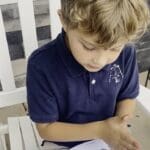 A young boy sitting on top of a chair.